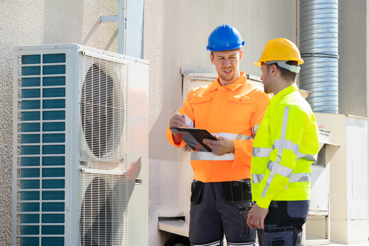 Two HVAC professionals on the job after HVAC technician training