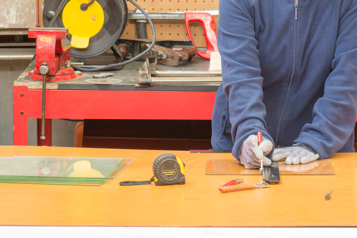 An apprentice millwright executing a measuring and cutting task during welder training