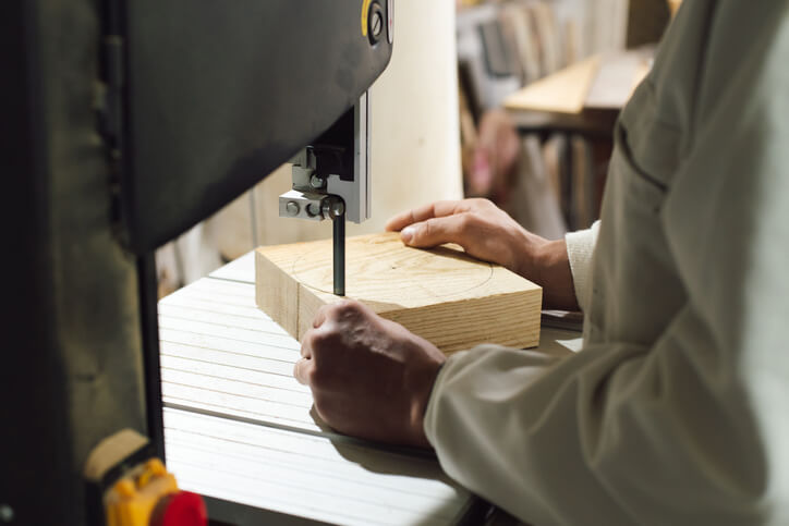 A Cabinetmaker operating a machine after cabinet-making training