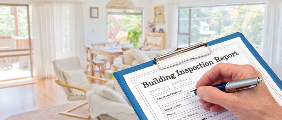 A home inspector holding an inspection report after home inspection training.