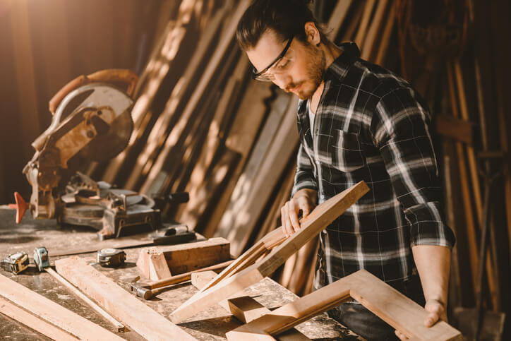 Male cabinet maker in a workshop after completing his cabinet making diploma program