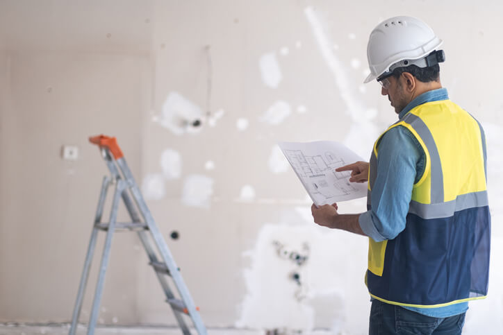 A home renovation technician holding a blueprint after home renovation training