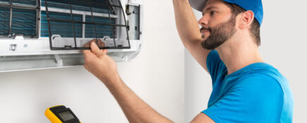 An HVAC training technician graduate replacing an air conditioner part.
