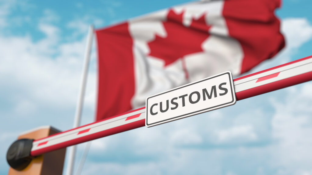 Canadian flag behind customs clearance barrier gate 